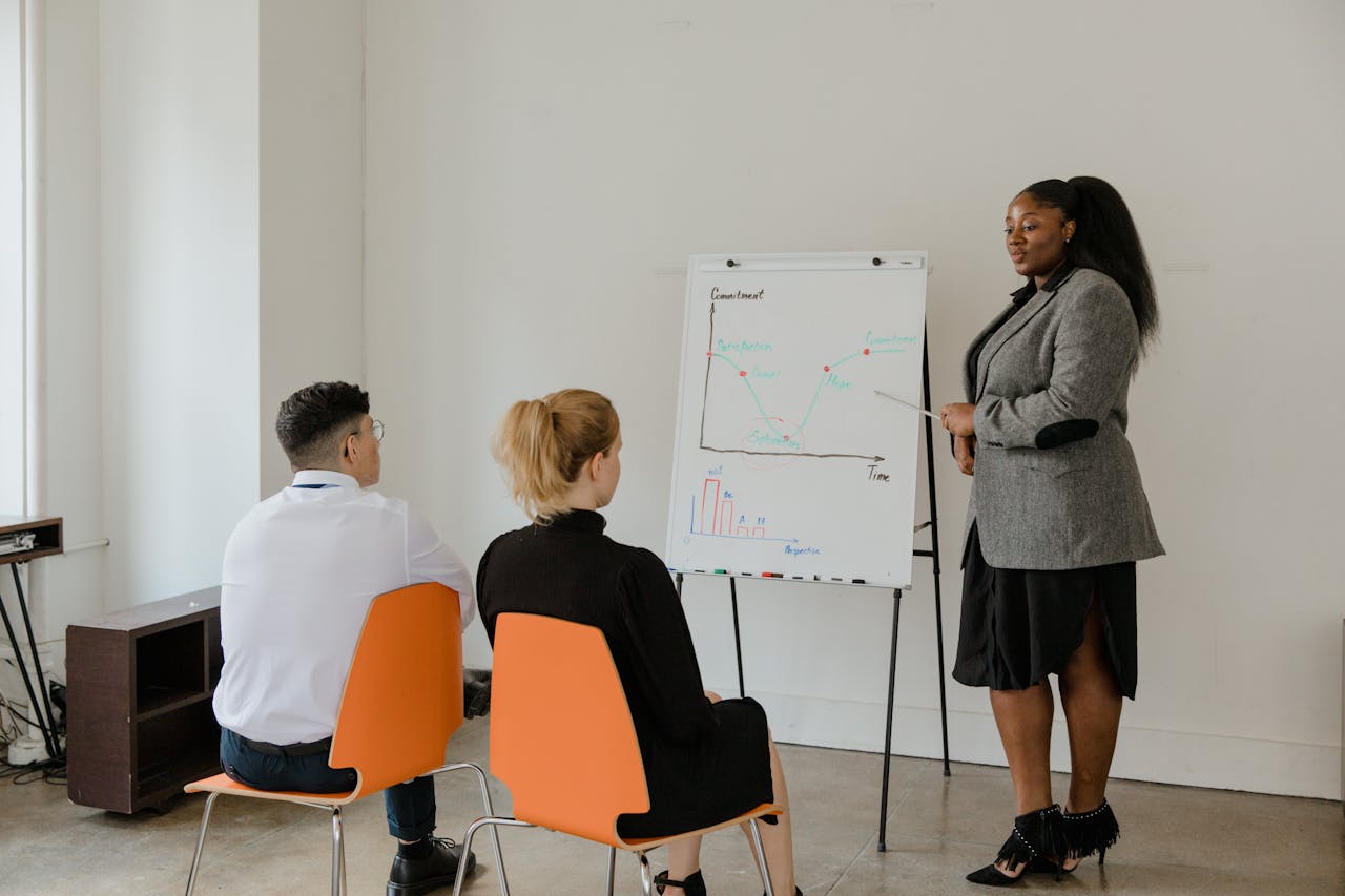 A diverse group of coworkers in an office setting engaged in a presentation.